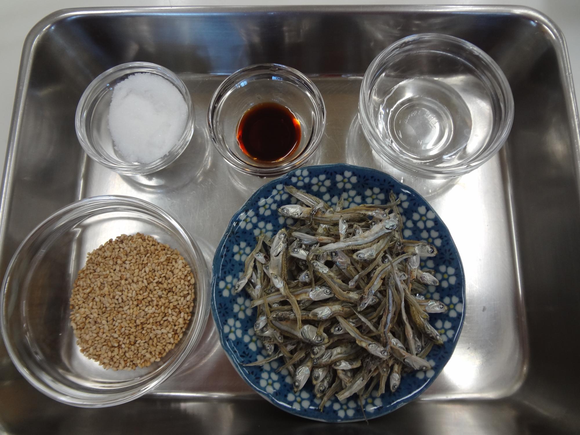 手前から左:ゴマ、右:ごまめ、奥の左:砂糖、中:醤油、右:水がバットに準備されている写真