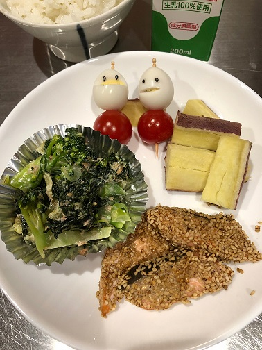鮭のごま焼き、おかか和え、うずら卵とミニトマトの串、蒸しサツマイモが載ったお皿の写真