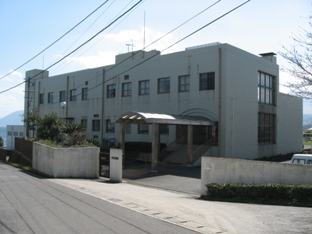白い建物の日出町浄化センター管理棟の写真