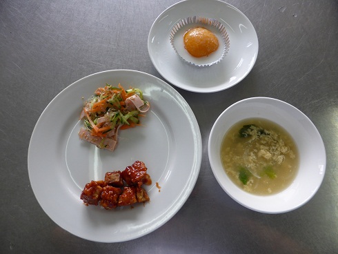 手前の左の白い大きなお皿の手前に魚のオーロラソース、奥にプチマリンのサラダ、手前右側の白い中皿に盛られた卵スープ、奥に目玉焼きのような桃のデザートが並べられている写真
