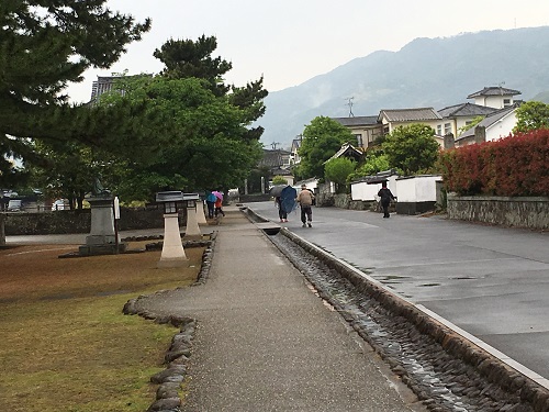 奥に山が見え、手前の道路で清掃作業をしている人達の写真