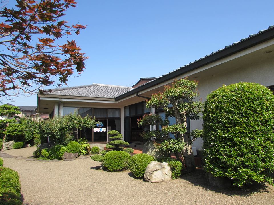 日本庭園風の広い庭とガラス張りの建物の様子