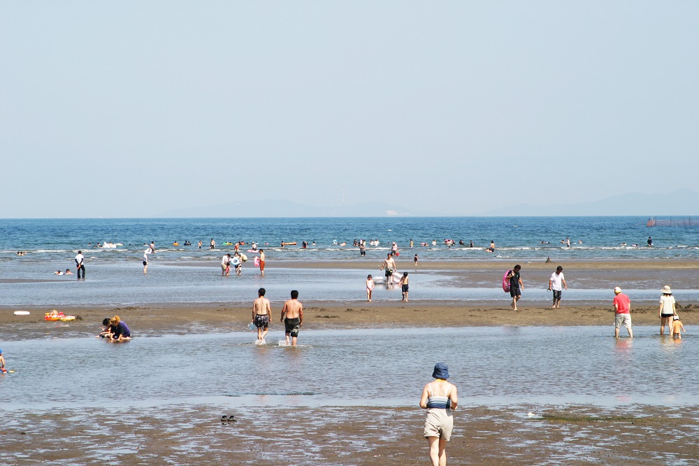 たくさんの人が海辺で遊んでいる様子の写真