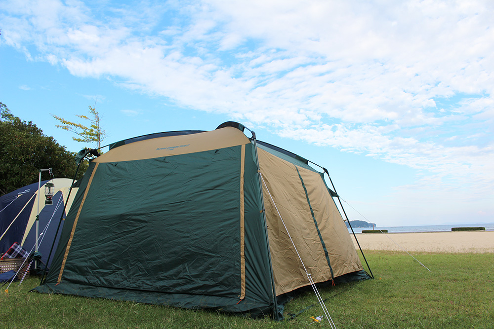 青空を背景に芝生の上に張られたテントの写真