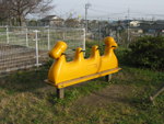 三川街区公園の遊具の一つである黄色い三人乗りのスプリング遊具の写真