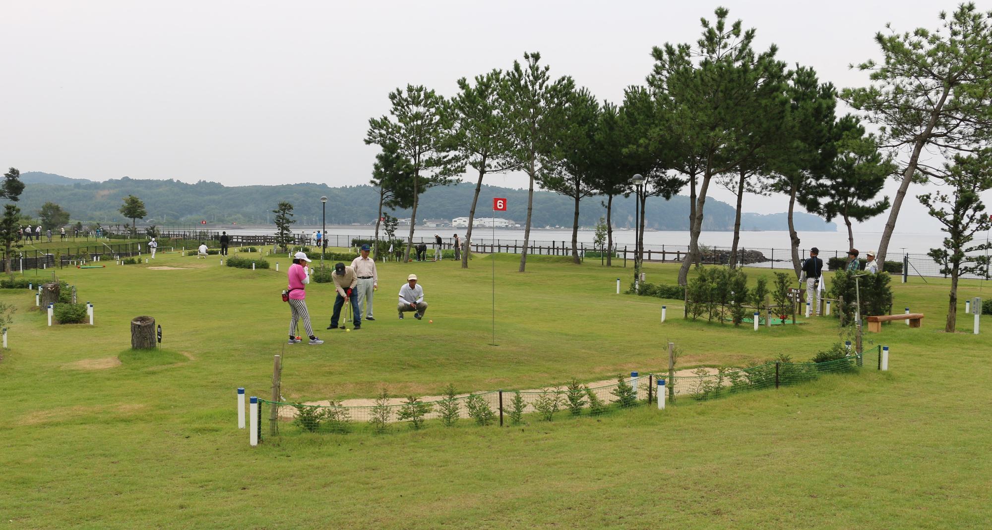 糸ヶ浜パークゴルフ場で大勢がパークゴルフを楽しむ様子を遠くから撮った写真