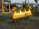 3人乗りの黄色の乗り物に、緑の持ち手がついているスプリング遊具の写真