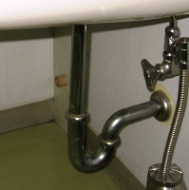 洗面台下のぐにゃりと曲がった排水管の写真