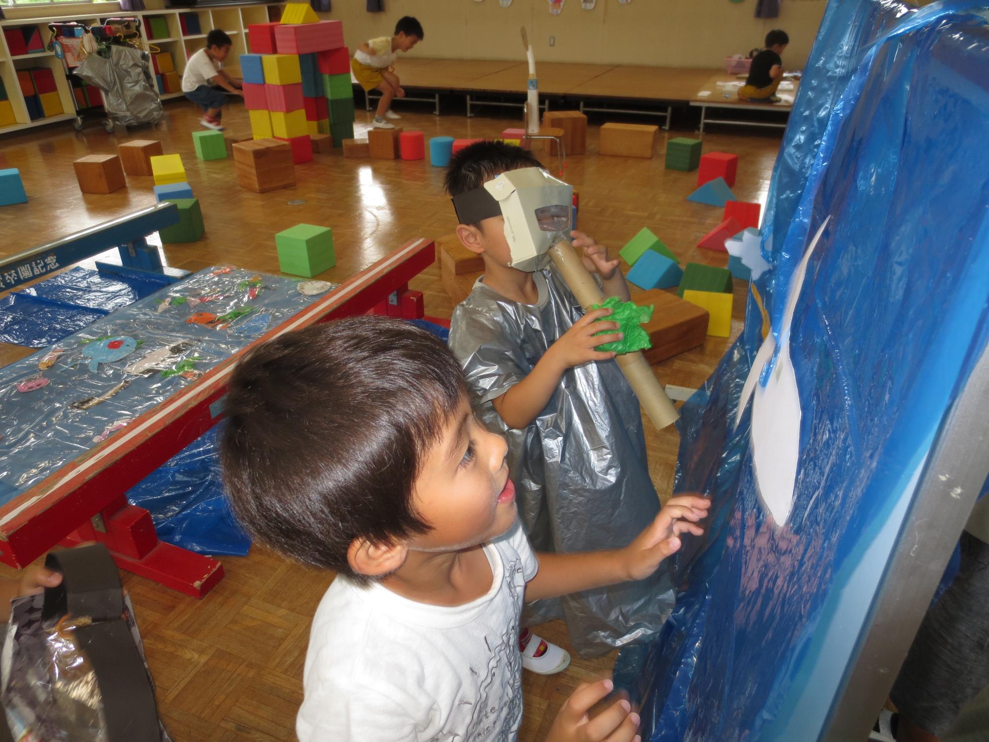 幼稚園ホールでみんなでうみたまごごっこ遊びをする様子の写真