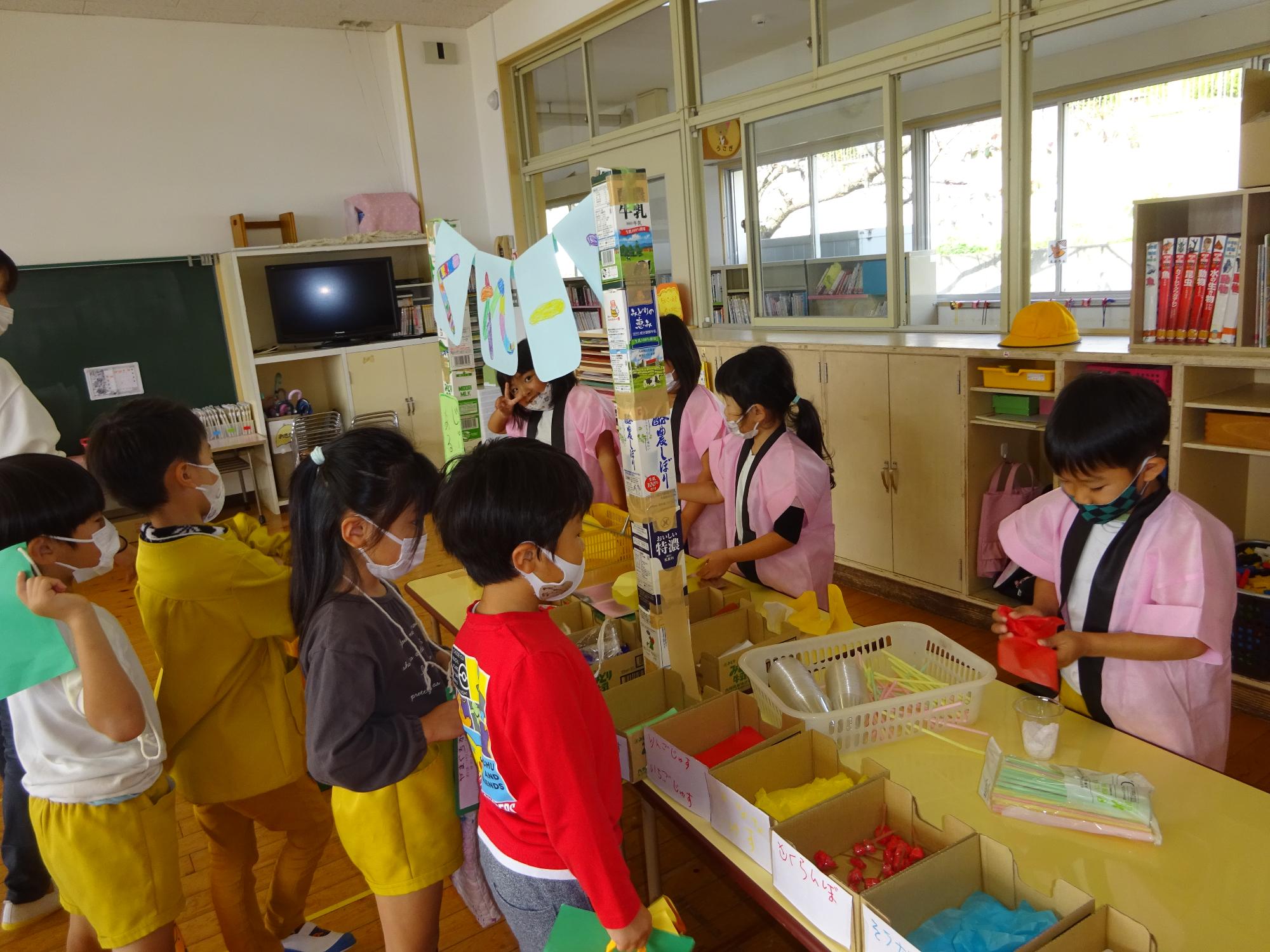 小学生と秋祭りをして遊ぶ幼稚園児の写真