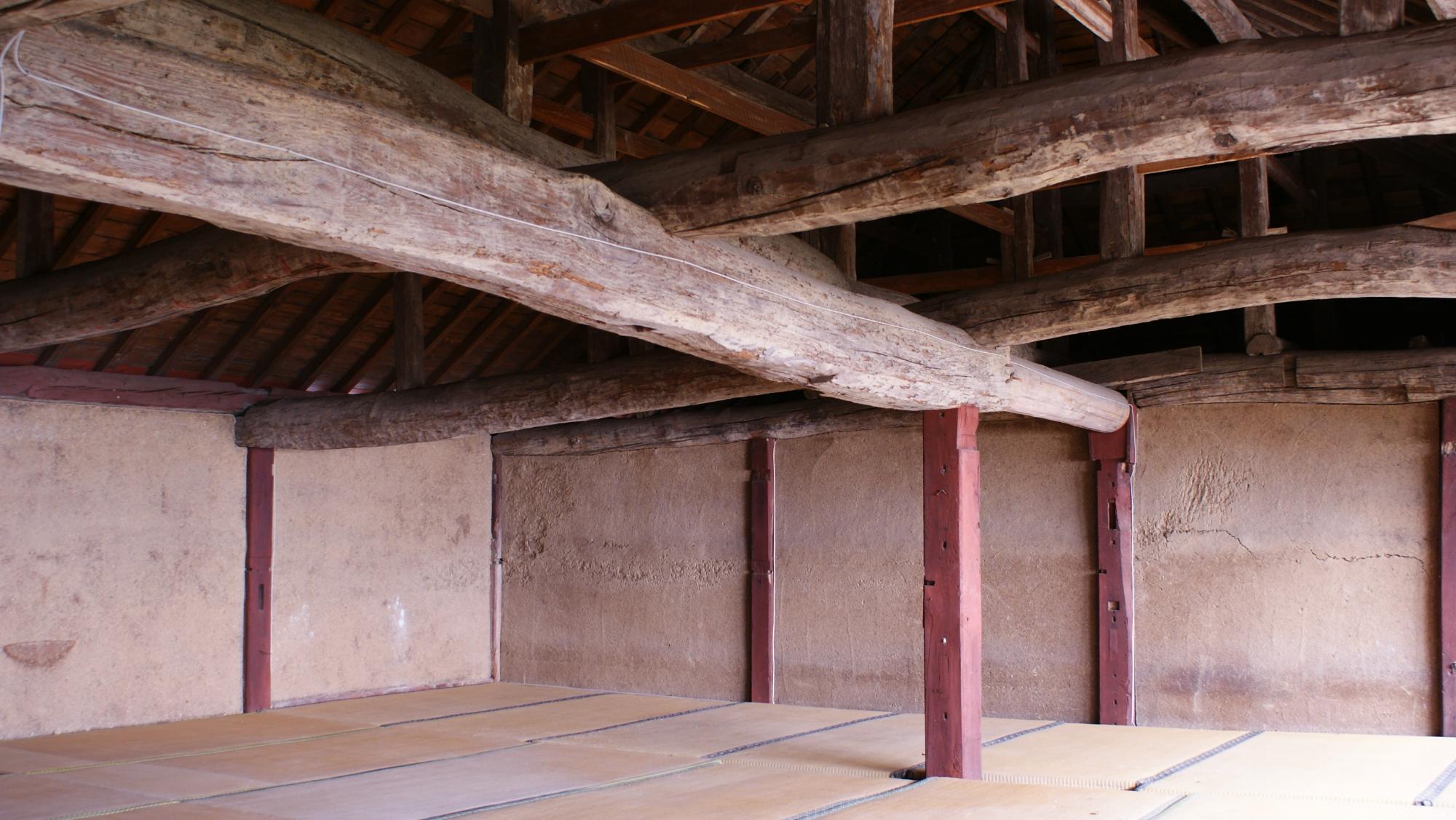 致道館建物2階内部の大きな梁と赤く塗られた柱の画像