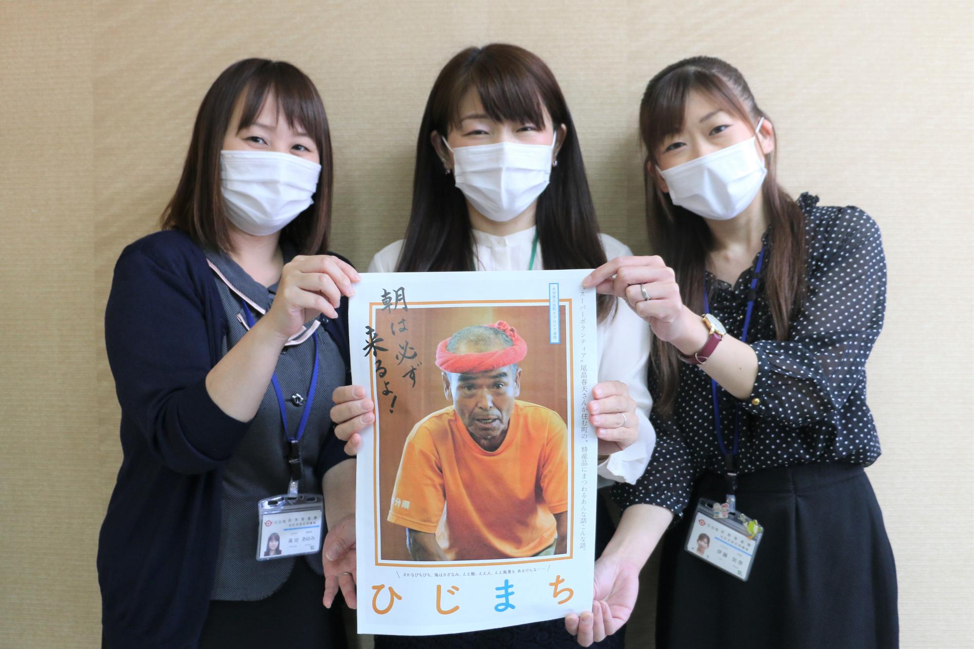 スーパーボランティア尾畠春夫さんが表紙の冊子を持った女性3人の写真