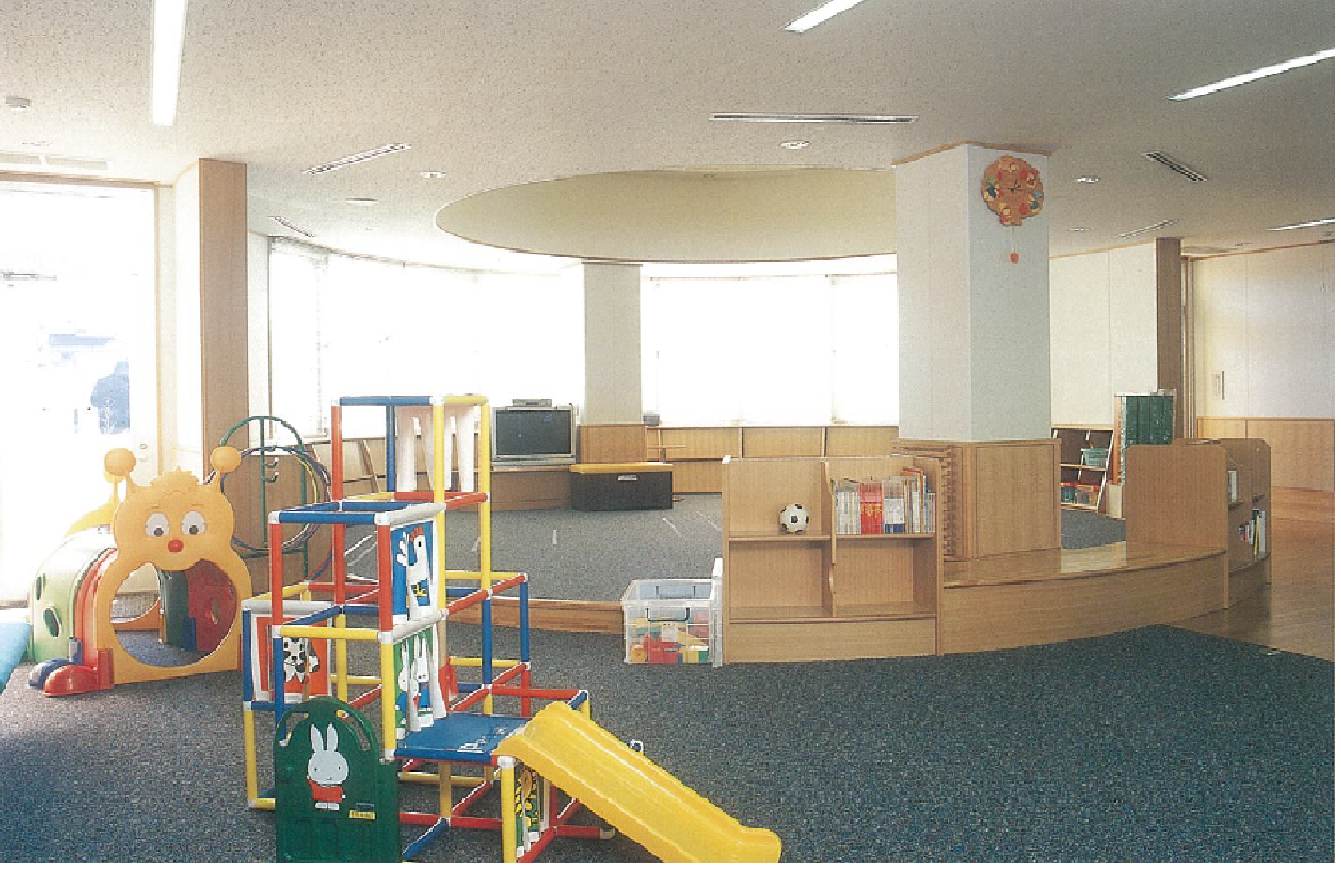 カーペットの敷かれた室内にジャングルジムやおもちゃのある、児童館の写真